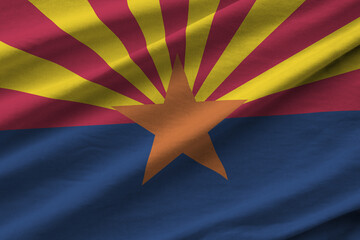 Arizona US state flag with big folds waving close up under the studio light indoors. The official...