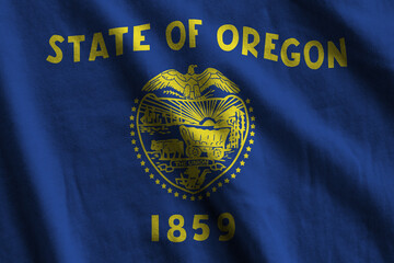 Oregon US state flag with big folds waving close up under the studio light indoors. The official...