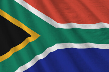 South Africa flag with big folds waving close up under the studio light indoors. The official symbols and colors in banner