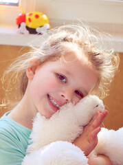 Little Child Girl Hugging Her Toy Bear At Home. Little girl sharing secrets with her small toy friend.	