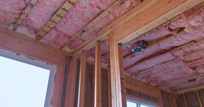 As part of the wall framing process mineral fiber glass wool is installed between beams to provide thermal and sound insulation