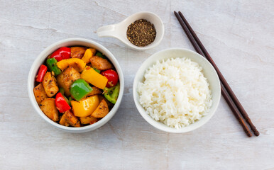 Food healthy stir fried chicken add sweet pepper has rice in bowl on wood table.