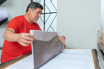 Man working with a garment print in a workshop