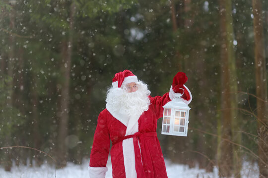 Santa Claus with bag of Christmas gifts is walking through snowy forest. Animator or parent in Santa Claus costume is rushing to a holiday for children. St. Nicholas Day. - Powered by Adobe
