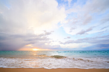 Seascape with sunset on the ocean shore. Beautiful cloudy sky.