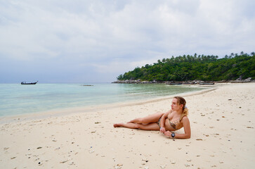 Vacation on the seashore. Young woman lying on the beautiful tropical beach.