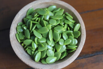 lamtoro seeds in a wooden bowl