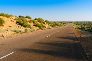 Morning in desert with empty high road or national high way passing through the desert. Distant horizon, Hot summer at Thar desert, Rajasthan, India.