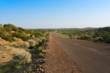 Fototapeta na wymiar Morning in desert with empty high road or national high way passing through the desert. Distant horizon, Hot summer at Thar desert, Rajasthan, India.