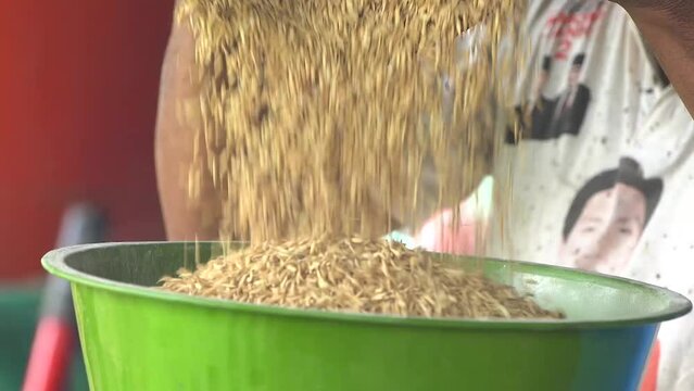 close-up video of rice being spilled into the container of a grinding machine.