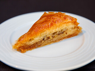 Piece of Carrot Slice Baklava (Turkish: Havuc Dilim Baklava) on white plate. Traditional Baklava from Gaziantep, Turkey. Baklava with walnut close up.