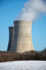 Nuclear power plant in the winter . Cooling towers. Blue sky in the background. Snow on the...