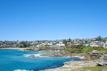 Sydney eastern suburbs headland, cloudless blue skies and waves crashing against the rocks, as seen...