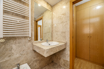 En-suite bathroom with marble countertops, inlaid wall mirror and white heated towel rail and hallway cabinets