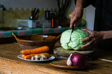 Hands of a person cutting cabbage and preparing sauerkraut.