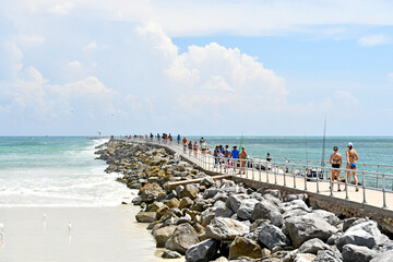 Tourists and locals enjoying a sunny day along the Ponce Inlet Jetty in Volusia County, Florida. 