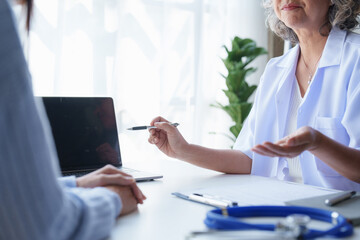 Doctor having conversation with patient while discussing explaining symptom and hold hand for encourage