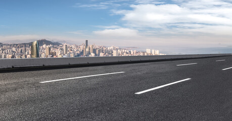 Fototapeta premium Background of asphalt pavement and urban architectural landscape skyline