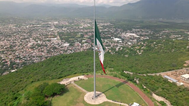 Giant Mexican flag flies in the wind at the top of the hill in Iguala, Guerrero, Mexico