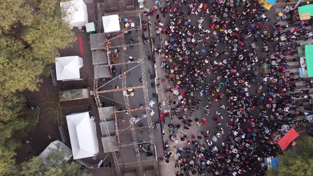 Descending aerial top down shot Chacarera folk dance on stage in street of Buenos Aires - People celebrating show outdoors