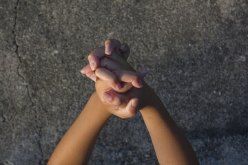 It is a child's hand holding two hands together.