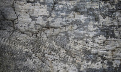 A weathered concrete wall with cracks and peeling paint, showing signs of age and decay.