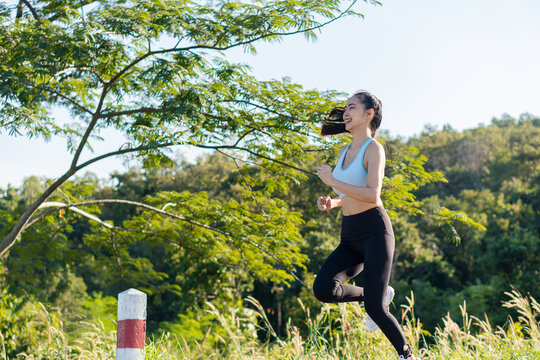 Cropped view of young asian woman exercising outdoors in the park, jogging, beach Get in shape with a combination of outdoor fitness models.