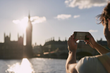 Man photograph Big Ben on phone in London, traveling and tourism, holiday sightseeing and famous...