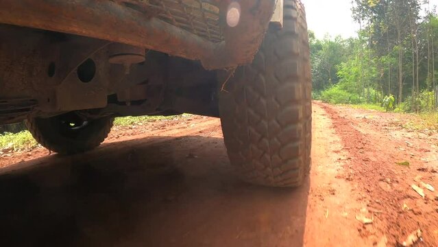 4x4 off road Pickup car wheels are running on a dirt road. Off-road truck car wheels moving on the dirty road with dust, wet and dry mud.  Point of view 4WD truck tire travel in the backcountry place