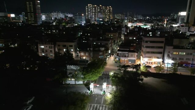 South Korea Daegu city night drone flight descending to downtown district neighbourhood streets