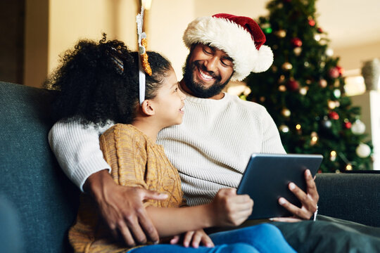 Christmas, family and digital tablet for live streaming movie, fun game or social media on house living room sofa. Happy smile mother, father and girl with technology in home in festive xmas holiday