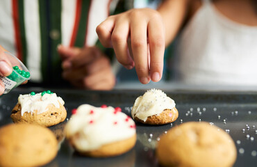 Girl hands, decorating cookies and closeup with sparkles, cream or candy in kitchen for learning....
