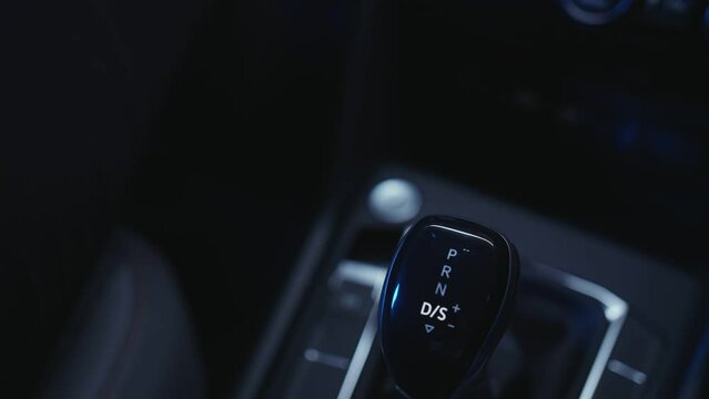 a man with a watch on his arm switches an automatic transmission