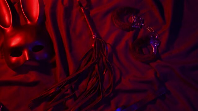 Handcuffs, leather whip flogger, mask and choker for BDSM sex with submission and domination. Concept of erotic adult sex toys