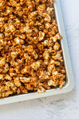 homemade salted caramel butter popcorn in baking tray on marble background