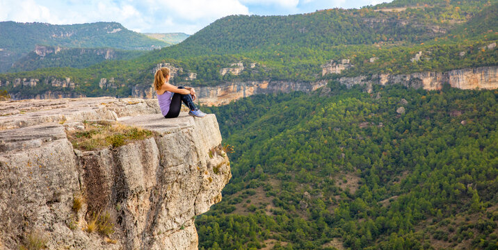 climber woman sitting on mountain peak enjoying panoramic landscape view ( Siurana in Spain)