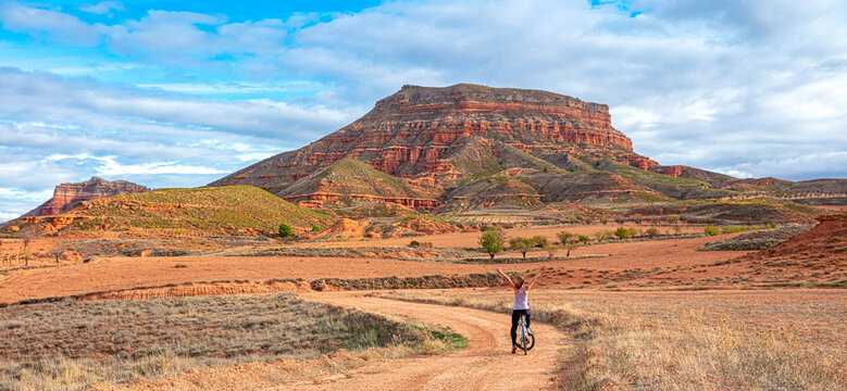 Woman cyclist riding with mountain bike in the desert ( sierra armantes, Aragon in Spain- Zaragoza province)