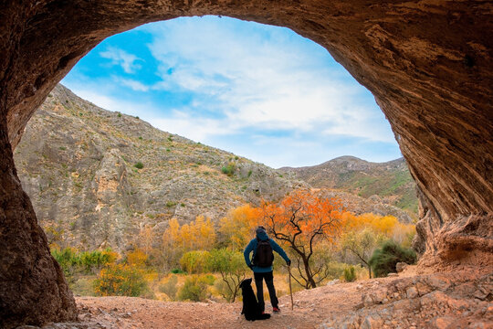 Hiker with backpack in cave ( Peña Agujereada, Aragon in Spain)