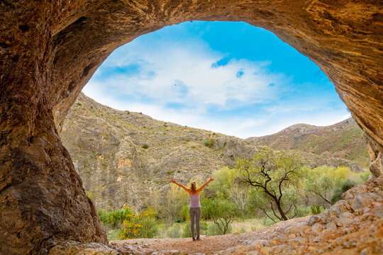 Hiker woman in cave ( Peña Agujereada, Aragon in Spain)