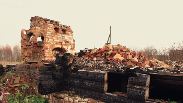 Charred walls and a destroyed stove, the remains of a burnt house. An abandoned wooden building, a consequence of the war, bombing, rocket attacks. Ruins, people in evacuation. UHD 4K.