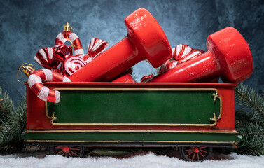 Dumbbells, candy canes decorations and red ornaments in a Christmas train car wagon carriage....