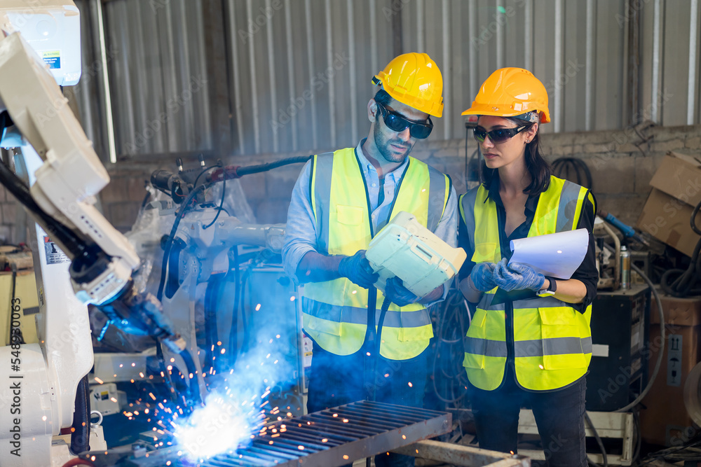 Aufkleber male engineer and female technician maintenance control robot arm system welding with robot controll