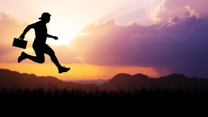 Silhouette of a man jumping in the meadow. The business concept moves forward in the future.