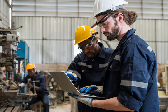 Diversity factory male engineer workers working with laptop computer in the factory. Group of factory male worker working and discuss at industry factory