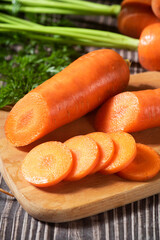 cut of fresh carrots on rustic wooden background. 