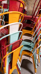 stack of multicolored chairs of Industrial Metal Chair on restaurant terrace