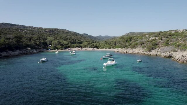 Boat at Las Cricas cove in Tizzano Beach on French Corsica Island Mediterranean Sea, Aerial dolly out reveal shot