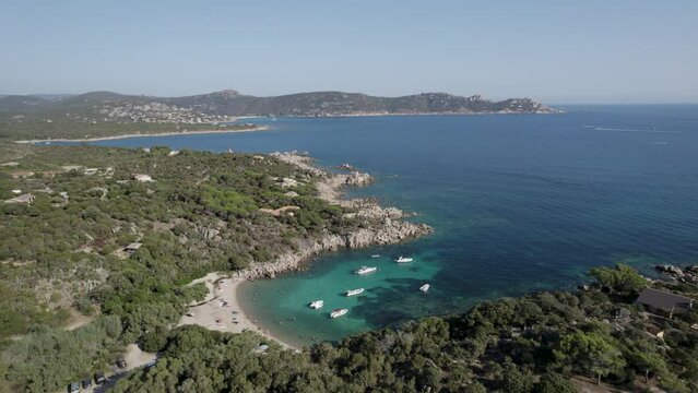 Tizzano Beach and Las Cricas cove on French Corsica Island Mediterranean Sea with small boats, Aerial pan left reveal shot