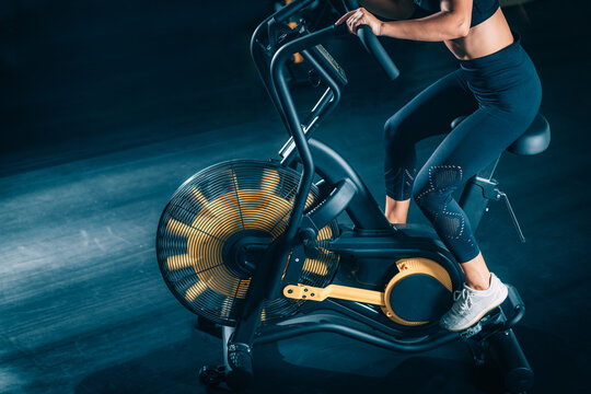 Cardio Workout. Woman using Air Bike in the Gym.