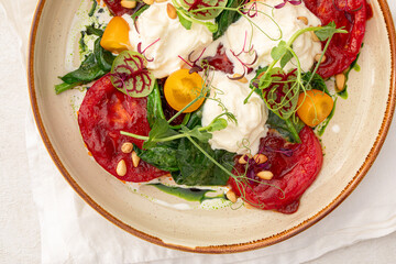 Portion of grilled tomatoes and stracciatella cheese
